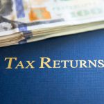 Dollars and Folder with Tax Returns